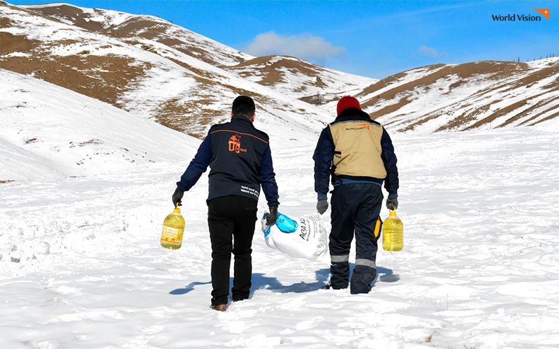 코로나19로 인해 생계의 위협을 받고 있는 취약계층에게 식량을 배송하고 있는 몽골 월드비전 직원들.눈밭을 걷고 있는 모습.