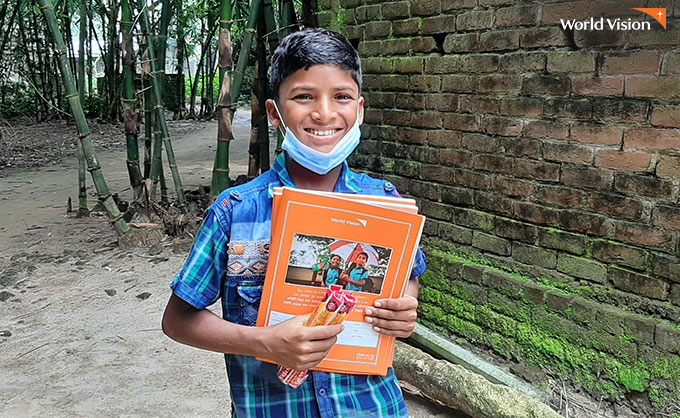 학용품을 받고 웃고 있는 방글라데시 남학생. 사진