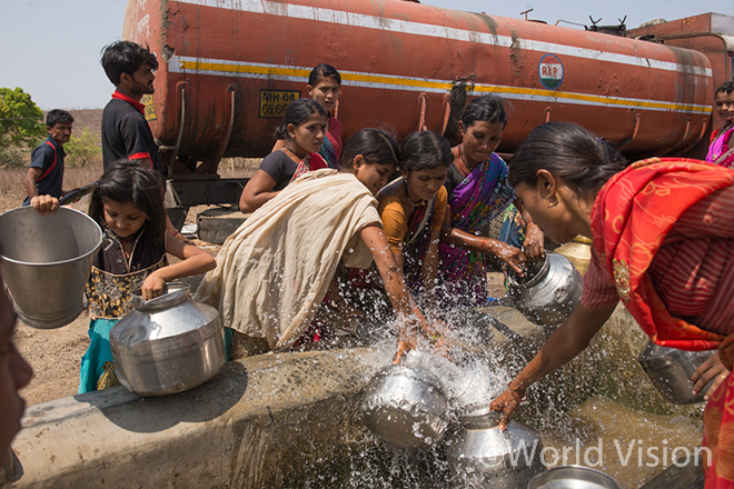 정부가 제공한 물탱크에서 물을 긷는 주민들(사진출처:월드비전)
