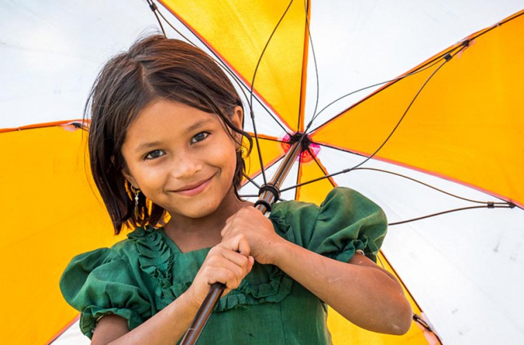 여자아이가 월드비전 우산을 들고 웃는 모습