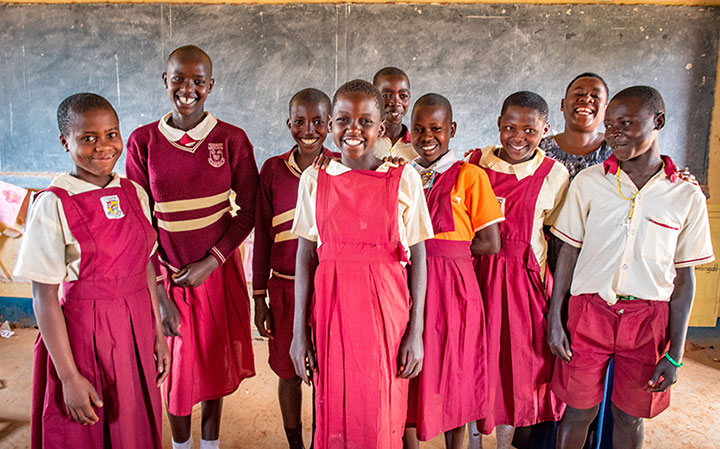 교실 칠판 앞에 서있는 교복을 입고 탄자니아 여학생들