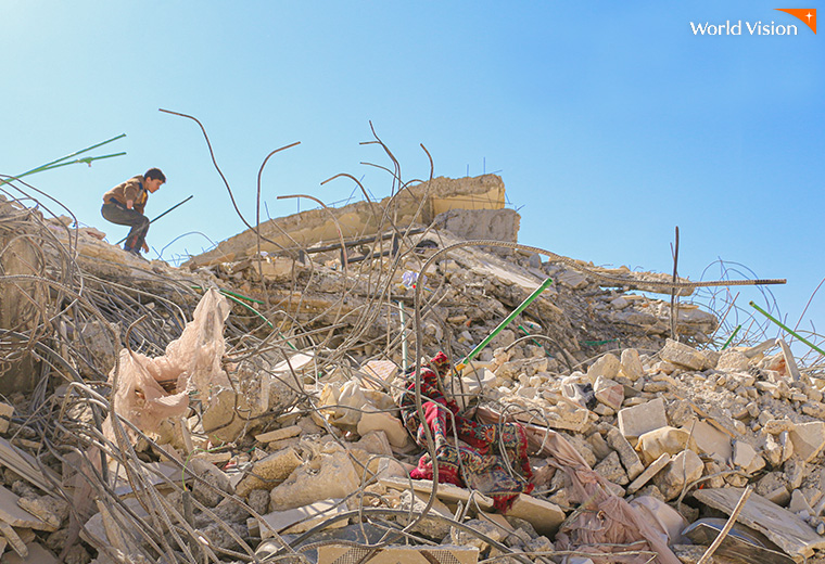 지진으로 무너진 건물위에 서있는 아이